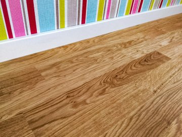Dřevěnou dubovou podlahu je možné kombinovat také s bílou hranatou vyšší soklovou lištou (6cm)